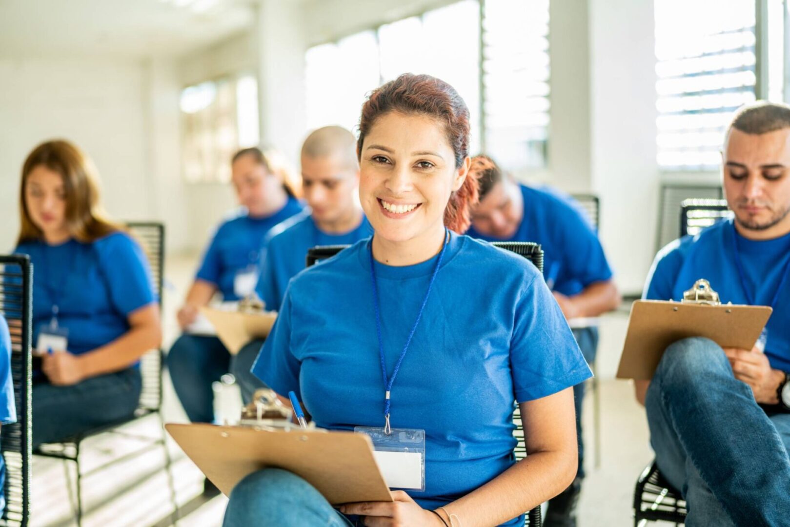 People in blue shirts taking notes