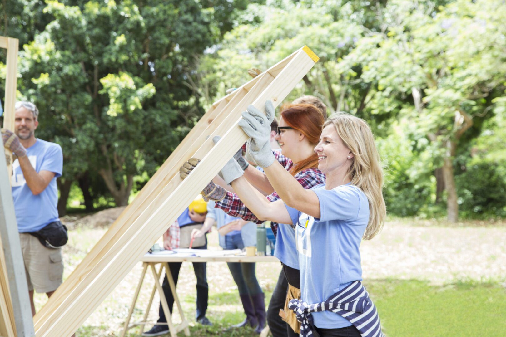 Volunteers building a wooden structure outdoors